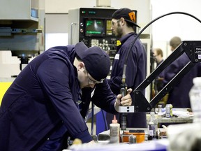 Valiant apprentice Kyle White, left, and others in the Earn While you Learn program designed to train CNC machinists, welders and robot programmers at Valiant's training facility February 22, 2012.  (NICK BRANCACCIO/The Windsor Star)