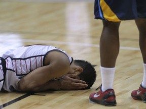 Windsor's Kevin Loiselle, left, lies on the floor after being fouled against Saint John at the WFCU Centre. (DAN JANISSE/The Windsor Star)