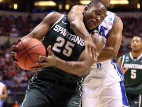 Michigan State's Derrick Nix, left, is hit by Duke's Tyler Thornton during the Midwest Region Semifinal round of the 2013 NCAA Men's Basketball Tournament at Lucas Oil Stadium in Indianapolis, (Photo by Andy Lyons/Getty Images)