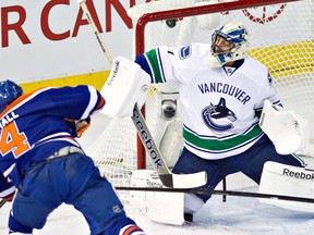 Former Spitfire Taylor Hall, left, scores a goal on Vancouver goalie Roberto Luongo Saturday in Edmonton (THE CANADIAN PRESS/Jason Franson)
