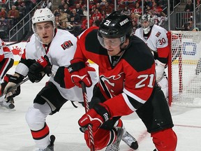 Ex-Spit Andrei Loktionov, right, is checked during his first game with the Devils against Ottawa. (Photo by Bruce Bennett/Getty Images)