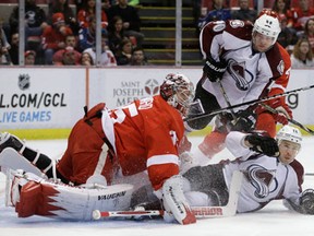 Colorado's Chuck Kobasew, right, slides into Detroit's  (12) slides into Detroit Red Wings goalie Jimmy Howard Tuesday. (AP Photo/Carlos Osorio)