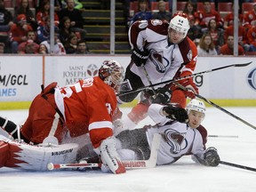 Colorado Avalanche right wing Chuck Kobasew (12) slides into Detroit Red Wings goalie Jimmy Howard (35) during the first period of an NHL hockey game in Detroit, Tuesday, March 5, 2013. (AP Photo/Carlos Osorio)