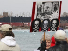 Protesters demonstrate at Assumption Park, directly across from piles of petroleum coke stored on the American side of the Detroit River.  (DAX MELMER/The Windsor Star)