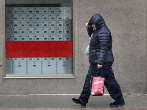 A pedestrian walks in downtown Windsor, Ont. Monday, March 25, 2013, on a snowy spring day.  (DAN JANISSE/The Windsor Star)