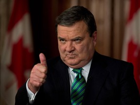 In this file photo, Finance Minister Jim Flaherty gives a thumbs up as he takes part in a TV interview after tabling the federal budget in the House of Commons on Parliament Hill in Ottawa on Thursday March 21, 2013. THE CANADIAN PRESS/Adrian Wyld