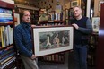 Mark Reesman, left,  and Roger Wurdeman owner of Juniper Books, hold a Japanese woodblock print called Geshas Strolling Among the Waterfalls, at the book store on Ottawa Street in Windsor. (JASON KRYK / The Windsor Star)