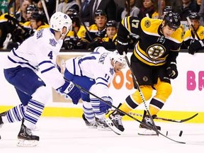 Boston's Milan Lucic carries the puck in front of Toronto's Cody Franson, left and Jay McClement on March 7, 2013 at TD Garden in Boston, Massachusetts. (Photo by Jared Wickerham/Getty Images)