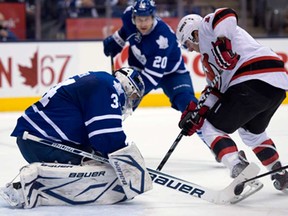 Toronto goaltender James Reimer, left, makes a save on New Jersey's Stephen Gionta, right, during first-period NHL action in Toronto Monday March 4, 2013. (THE CANADIAN PRESS/Frank Gunn)