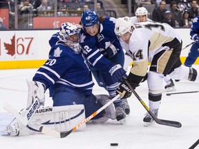 Maple Leafs forward Tyler Bozak, centre, battles for the puck against Pittsburgh's Chris Kunitz, right, in front of goaltender Ben Scrivens during the first period in Toronto on Thursday March 14, 2013.THE (CANADIAN PRESS/Chris Young)