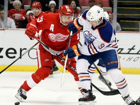 Detroit Red Wings center Pavel Datsyuk (13), of Russia, and Edmonton Oilers center Ryan Nugent-Hopkins (93) chase a loose puck during the first period of an NHL hockey game on Thursday, March 7, 2013, in Detroit. (AP Photo/Duane Burleson)