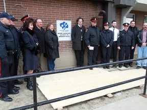 Residents, police and community partners pose with a new Neighbourhood Watch sign at 920 Ouellette Ave. on Mar. 19, 2013. (Tyler Brownbridge / The Wndsor Star)
