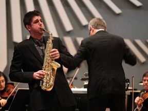 WSO assistant conductor Peter Wiebe, right, leads the orchestra as saxophonist Marc Funkenhauser performs during Intimate Classics at Assumption University Chapel on Friday. (NICK BRANCACCIO / The Windsor Star)