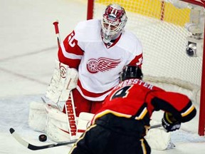 Calgary's Jay Bouwmeester, right, scores against Detroit's Jonas Gustavsson in first period  on March 13, 2013 at the Scotiabank Saddledome in Calgary, Alberta, Canada. (Photo by Mike Ridewood/Getty Images)