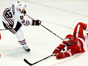 Red Wings defenceman Brendan Smith, right, blocks a shot by Chicago's Michal Rozsival Sunday, March 3, 2013, in Detroit. The Blackhawks won 2-1 in a shootout. (AP Photo/Duane Burleson)