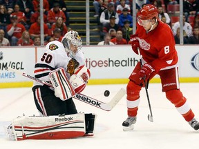 Chicago goalie Corey Crawford, left, makes a save on a shot by Detroit's Justin Abdelkader Sunday, March 31, 2013, in Detroit. The Blackhawks won 7-1. (AP Photo/Duane Burleson)