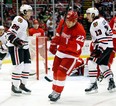 Chicago's Jeremy Morin, left, celebrates his goal with teammate Daniel Carcillo, right, as Detroit's Jordin Tootoo skates away Sunday, March 31, 2013, in Detroit. The Blackhawks defeated the Red Wings 7-1. (AP Photo/Duane Burleson)