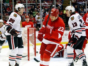 Chicago's Jeremy Morin, left, celebrates his goal with teammate Daniel Carcillo, right, as Detroit's Jordin Tootoo skates away Sunday, March 31, 2013, in Detroit. The Blackhawks defeated the Red Wings 7-1. (AP Photo/Duane Burleson)