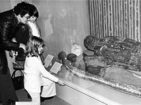 A display at the Art Gallery of Windsor of ancient Egyptian artifacts, including a mummy, should entice amateur Egyptologists and many who aren't. Mrs. Charles Dean, one of the leaders of the Temple Baptist Church family program, brought a group of children to the gallery on Jan. 5, 1977. Nicole Godwin, 8, of Oak Street, kneeling, and Crystal Hostine, 7, of Randolph Street, didn't find the mummy a bit scary during their visit.  (FILES/The Windsor Star)