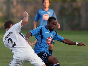 Steve Ademolu, right, of the Windsor Stars battles the University of Windsor's Eric Cirovski in exhibition soccer action at Windsor Stadium. (NICK BRANCACCIO/The Windsor Star)