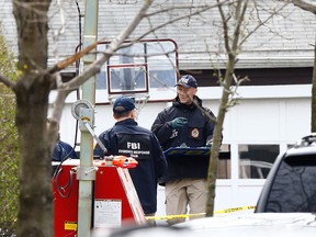 Members of law enforcement investigate the scene Saturday, April 20, 2013, where bombing suspect Dzhokhar A. Tsarnaev, 19, was caught Friday night on Franklin Street  in Watertown, Mass. The bombing, on April 15 at the finish line of the Boston Marathon, killed three people and wounded at least 170.(Photo by Jared Wickerham/Getty Images)