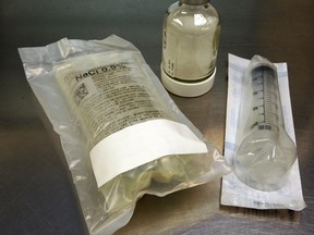 Typical bag of saline marked as 250 mL, left, with a dry powder and a syringe, Friday, April 12, 2013, at Windsor Regional Hospital Met campus. The syringe is used to reconstitute the dry powder by drawing fluid from the bag. (NICK BRANCACCIO/The Windsor Star)
