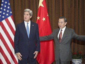 U.S. Secretary of State John Kerry, left, is escorted by Chinese Foreign Minister Wang Yi prior to their meeting at the Chinese Foreign Ministry Saturday, April 13, 2013 in Beijing. The question of how Washington can persuade Beijing to exert real pressure on North Korean leader Kim Jong Un's unpredictable regime is front and center as Kerry meets Saturday with Chinese leaders in Beijing. (AP Photo/Paul J. Richards, Pool