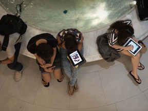 This picture taken on March 19, 2013 shows people using their smartphones and tablets in a shopping mall in Bangkok. A recent Facebook-sponsored study showed smartphone owners are often connected all day, creating a disconnection from their immediate surroundings. Experts are now concerned that children as young as four are becoming so addicted to smartphones and tablet computers that they require psychological treatment.Experts. (NICOLAS ASFOURI/AFP/Getty Images)
