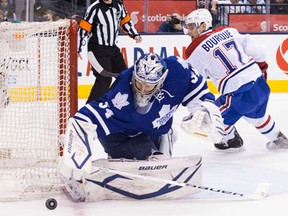 Toronto goaltender James Reimer, left, makes a save on Montreal's Rene Bourque. (THE CANADIAN PRESS/Chris Young)