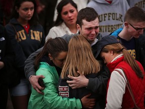 People hug and cry during a vigil for victims of the Boston Marathon bombings at Boston Commons on April 16, 2013 in Boston, Massachusetts. The twin bombings, which occurred near the marathon finish line, resulted in the deaths of three people while hospitalizing at least 140. The bombings at the 116-year-old Boston race, resulted in heightened security across the nation with cancellations of many professional sporting events as authorities search for a motive to the violence.  (Photo by Spencer Platt/Getty Images)