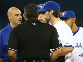 Jays pitcher R.A. Dickey, right, talks to trainer George Poulis as he left the game due to injury in the seventh inning against the Chicago White Sox at Rogers Centre in Toronto. (Photo by Tom Szczerbowski/Getty Images)