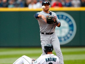 Detroit's Jhonny Peralta, right, turns a double play over Seattle's Robert Andino in the fifth inning at Safeco Field in Seattle.(Photo by Otto Greule Jr/Getty Images)