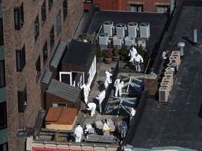Crime scene investigators inspect a rooftop above the sight of a bombing on Boylston Street April 18, 2013 in Boston, Massachusetts. Investigators continue to work the scene of a two-bomb explosion at the finish line of the marathon that killed 3 people and injured more than 170 others. (Photo by Darren McCollester/Getty Images)