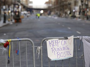 A sign hangs from a barricade on Boylston Street near the finish line of the Boston Marathon, Wednesday, April 17, 2013, in Boston. The city continues to cope following Monday's explosions near the finish line of the marathon. (AP Photo/Julio Cortez)