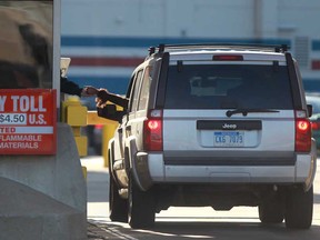 A commuter pays a toll at the Detroit-Windsor Tunnel before entering the United States, Sunday, April 21, 2013.  (DAX MELMER/The Windsor Star)