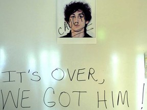 A sign in a Boston hotel lobby on April 20, 2013, shows a photo of Dzhokhar A. Tsarnaev, 19, the morning after he was captured. (Timothy A. Clary/AFP/Getty Images)