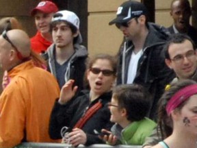 This Monday, April 15, 2013 file photo provided by Bob Leonard shows bombing suspects Tamerlan Tsarnaev, 26, center right in black hat, and his brother, Dzhokhar A. Tsarnaev, 19, center left in white hat, approximately 10-20 minutes before the blasts that struck the Boston Marathon. (AP Photo/Bob Leonar)