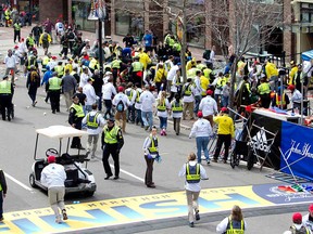 First responders rush to where two explosions occurred along the final stretch of the Boston Marathon on Boylston Street in Boston, Massachusetts, U.S., on Monday, April 15, 2013. Two powerful explosions rocked the finish line area of the Boston Marathon near Copley Square and police said many people were injured. (Photographer: Kelvin Ma/Bloomberg)