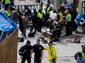 First responders tend to the wounded where two explosions occurred along the final stretch of the Boston Marathon on Boylston Street in Boston, Massachusetts, U.S., on Monday, April 15, 2013. Two powerful explosions rocked the finish line area of the Boston Marathon near Copley Square and police said many people were injured. (Photographer: Kelvin Ma/Bloomberg)