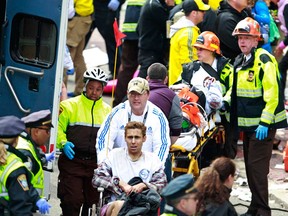 Medical workers aid injured people at the finish line of the 2013 Boston Marathon following an explosion in Boston, Monday, April 15, 2013. Two explosions near the finish of the Boston Marathon on Monday, killing at least  two people, injuring over 20 others. (AP Photo/Charles Krupa)