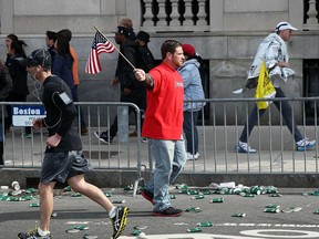 People walk near Kenmore Square after two bombs exploded during the 117th Boston Marathon on April 15, 2013 in Boston, Massachusetts. Two people are confirmed dead and at least 23 injured after two explosions went off near the finish line to the marathon.  (Photo by Alex Trautwig/Getty Images)