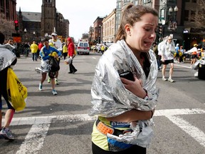 An unidentified Boston Marathon runner leaves the course crying near Copley Square following an explosion in Boston Monday, April 15, 2013. (AP Photo/Winslow Townson)