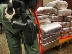 In this Nov. 4, 2010 file photo, bales of marijuana are wheeled out at a news conference in Jonesboro, Ga. Forty-five people were arrested 45 people along with cash, guns and more than two tons of drugs as part of an investigation by federal and local law enforcement into the Atlanta-area U.S. distribution hub of Mexico's La Familia drug cartel. Drug cartels have long been the nation’s No. 1 supplier of illegal drugs, but in the past, their operatives rarely ventured beyond the border. A wide-ranging Associated Press review of federal court cases and government drug-enforcement data, plus interviews with many top law enforcement officials, indicate the groups have begun deploying agents from their inner circles to the U.S. (AP Photo/Atlanta Journal-Constitution, John Spink)