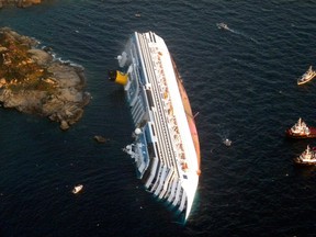 In this Jan. 14, 2012 file photo provided by the Guardia di Finanza (border Police), the luxury cruise ship Costa Concordia leans on its side after running aground off the tiny Tuscan island of Giglio, Italy. A judge in Tuscany fined Italian cruise line Costa Crociere SpA 1 million euros ($1.3 million) Wednesday, April 10, 2013 for the shipwreck that killed 32 people. (AP Photo/Guardia di Finanza, File)