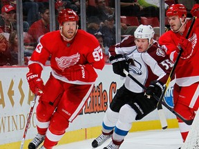 Detroit's Johan Franzen, left, is checked by Colorado's Cody McLeod at Joe Louis Arena. (Photo by Gregory Shamus/Getty Images)