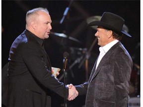 This April 6, 2009 file photo shows musician Garth Brooks, left, presenting George Strait with the Artist of the Decade award at the ACM Artist of the Decade All Star Concert in Las Vegas. Brooks and Strait will perform together for a tribute to the late Dick Clark at the 48th Annual Academy of Country Music Awards on April 7, 2013 in Las Vegas. (AP Photo/Mark J. Terrill)