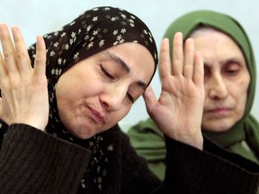 This April 25, 2013 file photo shows the mother of the two Boston bombing suspects, Zubeidat Tsarnaeva, left, speaking at a news conference in Makhachkala, the southern Russian province of Dagestan. Two government officials tell The Associated Press that U.S. intelligence agencies added the Boston bombing suspects' mother to a federal terrorism database about 18 months before the attack. At right is her sister-in-law Maryam. (AP Photo/Musa Sadulayev, File)