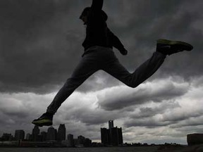 Brandon Kuik, 16, leaps over the rocks on the banks of the Detroit River under a dark overcast sky in Windsor, Ont., Saturday, April 13, 2013.  According to Environment Canada, overcast and rain conditions are expected throughout the week with temperatures returning to more seasonal levels.  (DAX MELMER/The Windsor Star)