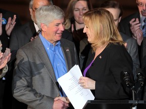 Michigan Gov. Rick Snyder (C) shakes hands with Lisa Raitt, Canada's Labour Minister, Friday, April 12, 2013, in Detroit, MI. Snyder announced a key permit to build a second bridge linking the United States and Canada from Detroit to Windsor. (DAN JANISSE/The Windsor Star)