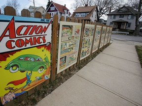 In this Tuesday, April 2, 2013 photo shows oversized Superman comic book pages displayed on a fence outside of what was once Joe Shuster's boyhood home in Cleveland. Superman collaborators Jerry Siegel and Shuster lived several blocks apart in the Glenville neighborhood which shaped their lives, dreams for the future and their imagery of the Man of Steel. (AP Photo/Tony Dejak)
